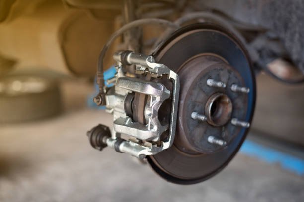car wheel brake disc and shoes of lifted automobile at repair service station